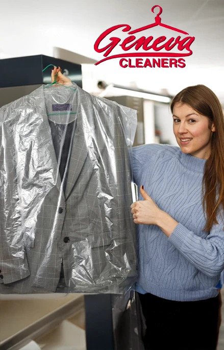 Woman holding a freshly cleaned gray plaid suit in plastic at Geneva Cleaners.